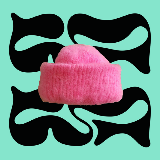 Hand-Knitted Pink Mohair Beanie with Fold-Over Cuff on Green Background