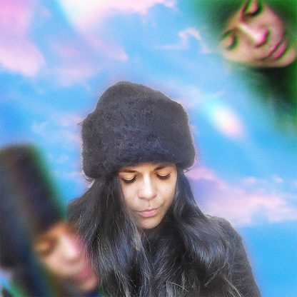 Person wearing a black hand-knitted mohair beanie with eyes closed, surrounded by a prism effect.